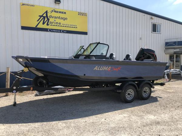 Slide: The Image of 2024 Alumacraft Trophy 195 boat on a trailer outside a marine sales and service shop. - 1