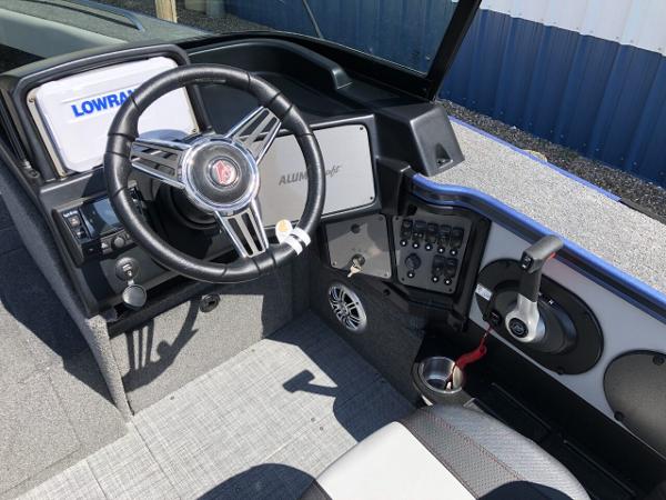 Slide: The Image of 2024 Alumacraft Trophy 195 boat cockpit with steering wheel and control panel. - 7