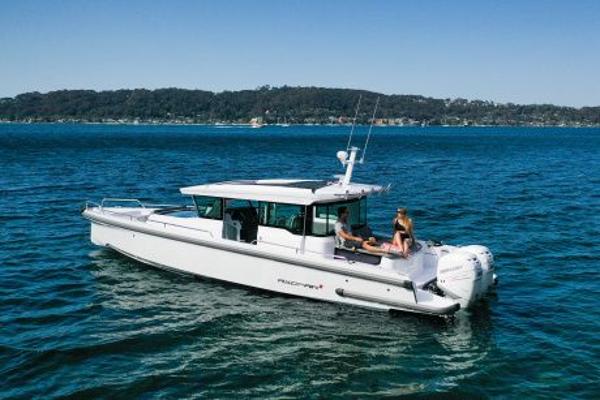 Slide: The Image of 2024 Axopar 37 XC Cross Cabin Aft Cabin cruising on a serene blue lake. - 1