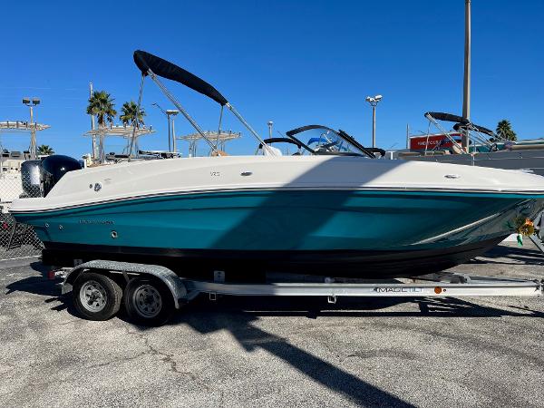Slide: The Image of 2020 Bayliner VR5 boat on a trailer, teal hull, and black canopy. - 0