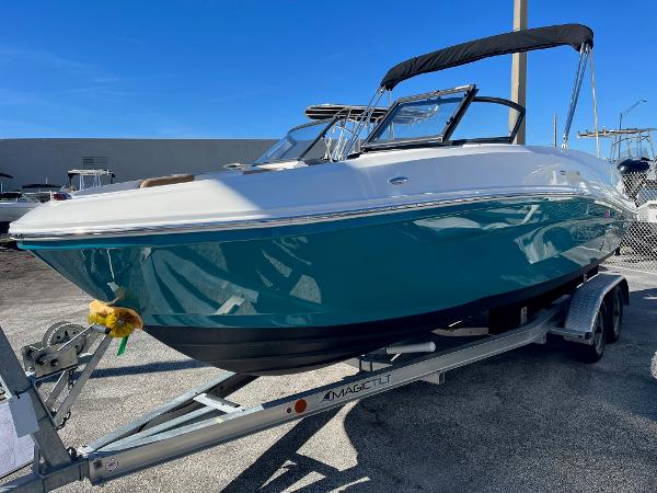 Slide: The Image of 2020 Bayliner VR5 boat on trailer, teal hull, black canopy, sunny day. - 1