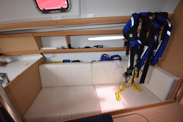 Slide: The Image of Interior of 2012 Beneteau First 30 sailboat with white seating and safety harnesses. - 27