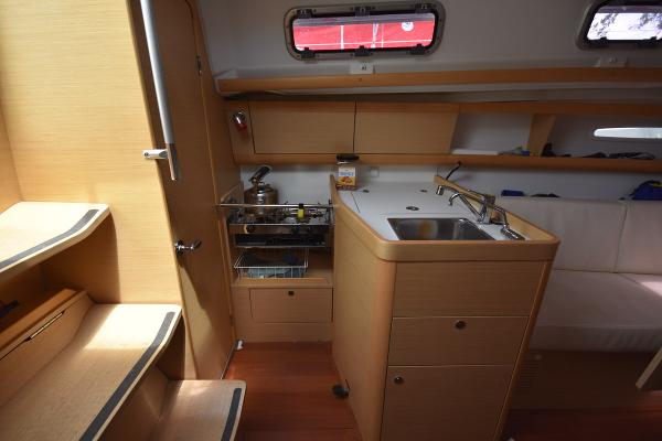Slide: The Image of Interior of 2012 Beneteau First 30 sailboat with compact kitchen and wooden cabinetry. - 31