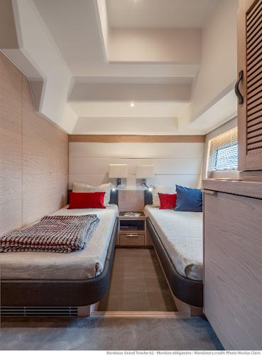 Slide: The Image of 2025 Beneteau Grand Trawler 62 cabin with twin beds, modern design, cozy ambiance. - 22