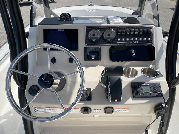Slide: The Image of 2023 Boston Whaler 210 Montauk boat dashboard with steering wheel and navigation controls. - 2