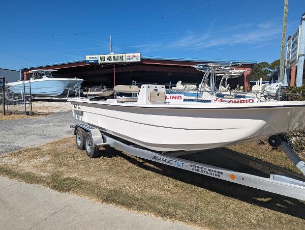 Slide: The Image of 2024 Carolina Skiff E Series 24ft CC boat on trailer at a marina. - 0