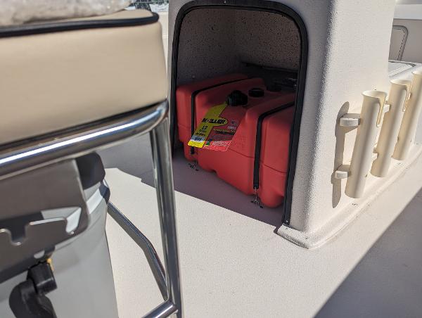 Slide: The Image of 2024 Carolina Skiff E Series 24ft CC boat storage compartment with red fuel tank. - 7