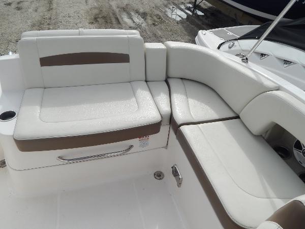 Slide: The Image of 2013 Chaparral 225 SSi boat interior seating area with white and brown upholstery. - 14