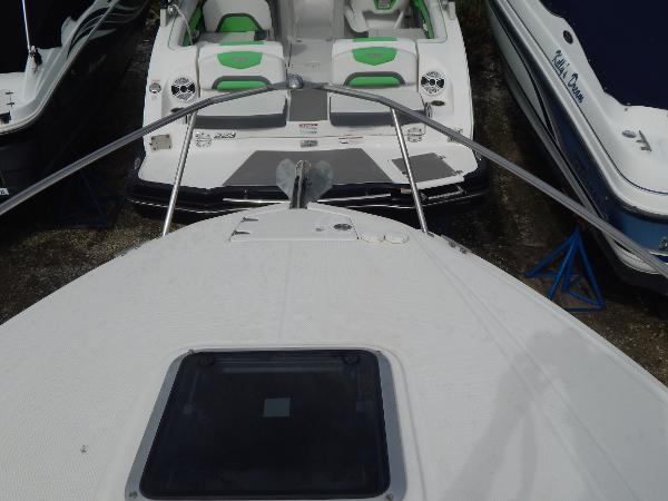 Slide: The Image of 2013 Chaparral 225 SSi boat, bow view, docked between other boats. - 26
