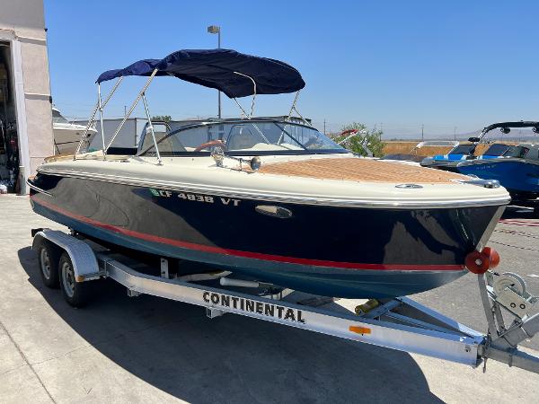 Slide: The Image of 2020 Chris-Craft Capri 21 boat on a Continental trailer with a blue canopy. - 1