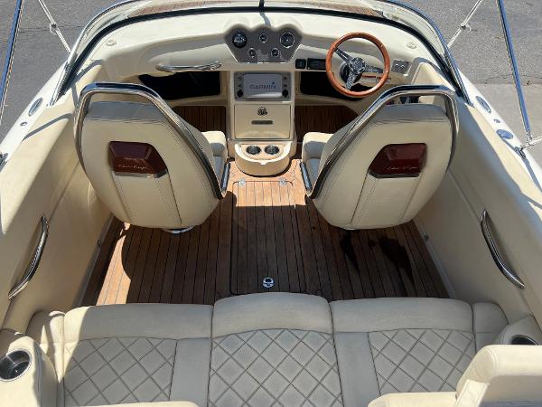 Slide: The Image of 2020 Chris-Craft Capri 21 boat interior with beige leather seats and wooden steering wheel. - 10
