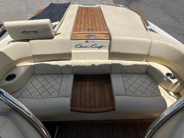Slide: The Image of 2020 Chris-Craft Capri 21 boat interior with beige leather seating and wooden accents. - 15