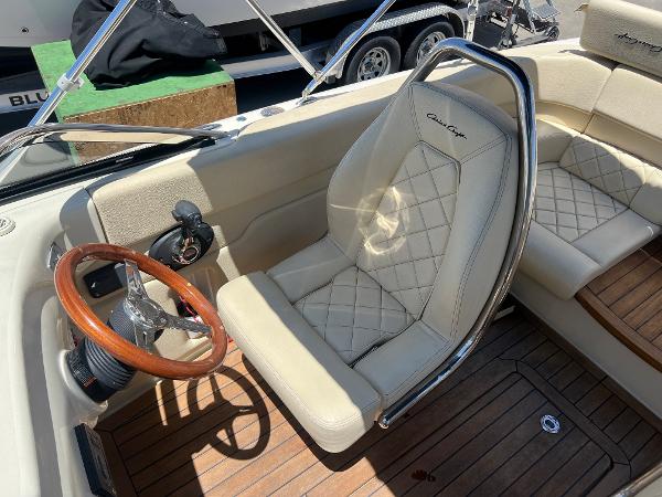 Slide: The Image of 2020 Chris-Craft Capri 21 boat interior with beige leather seats and wooden steering wheel. - 17