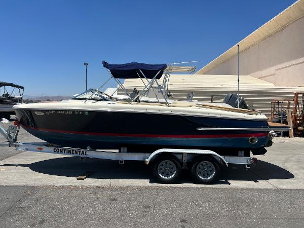 Slide: The Image of 2020 Chris-Craft Capri 21 boat on a Continental trailer, parked outdoors. - 2