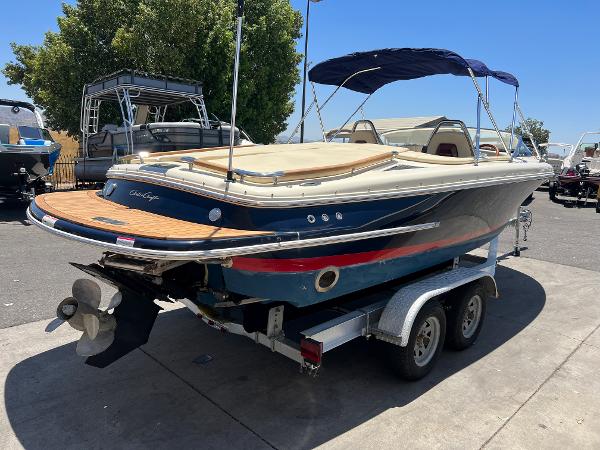 Slide: The Image of 2020 Chris-Craft Capri 21 boat on a trailer, parked outdoors. - 6