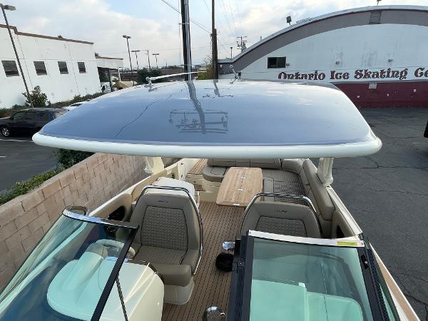 Slide: The Image of 2024 Chris-Craft Launch 31 GT boat interior with seating and table, parked near Ontario Ice Skating Center. - 12