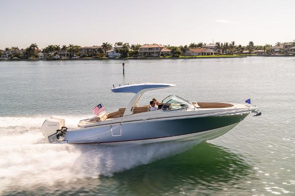 Slide: The Image of 2024 Chris-Craft Launch 31 GT cruising on a sunny day near waterfront homes. - 17