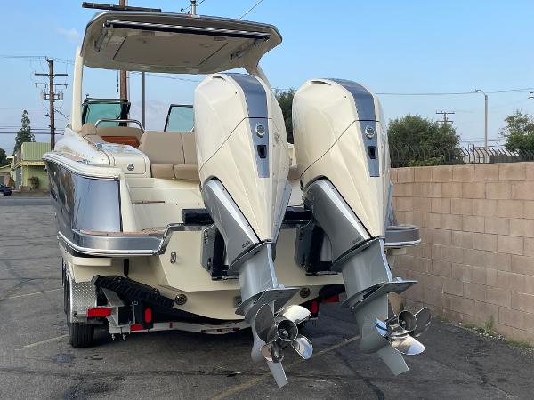 Slide: The Image of 2024 Chris-Craft Launch 31 GT boat with dual outboard engines, parked on a trailer. - 2
