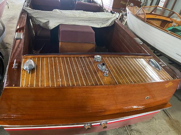 Slide: The Image of 1959 Chris-Craft Sportsman wooden boat with polished deck and red trim in storage. - 5