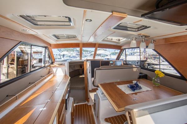 Slide: The Image of Interior of 2024 Cutwater 32 CB boat with modern wood finishes and dining area. - 2