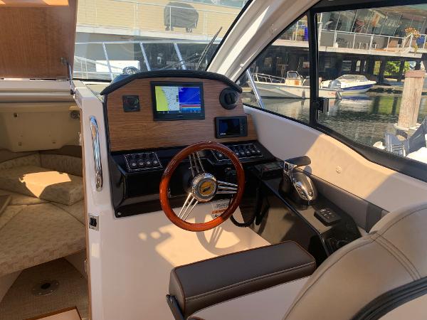 Slide: The Image of Interior helm of 2022 Cutwater C-24 Coupe with wooden steering wheel and navigation system. - 11
