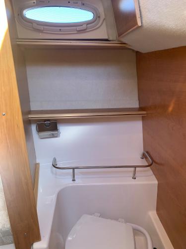 Slide: The Image of 2022 Cutwater C-24 Coupe boat interior bathroom with porthole and toilet. - 13