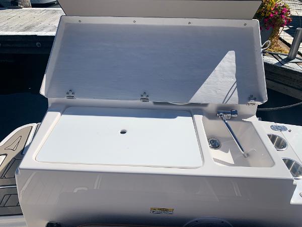 Slide: The Image of Cutwater C-24 Coupe 2022 boat with open storage compartment and sink. - 4