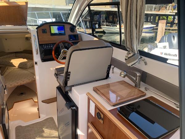 Slide: The Image of Interior of 2022 Cutwater C-24 Coupe boat with helm, kitchenette, and sleeping area. - 8