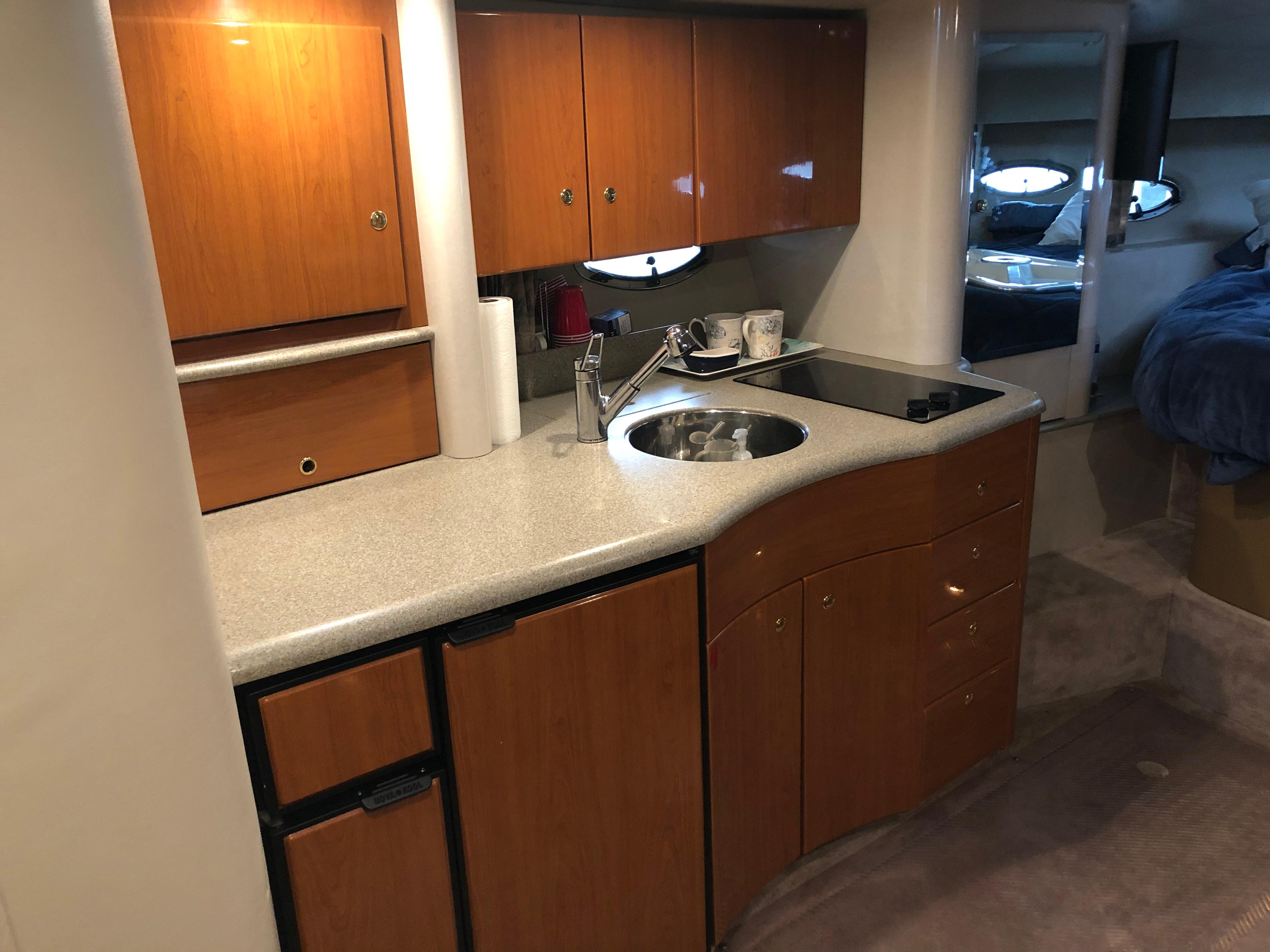 Slide: The Image of 2000 Formula 37 PC yacht interior kitchen with wooden cabinets and countertop. - 25