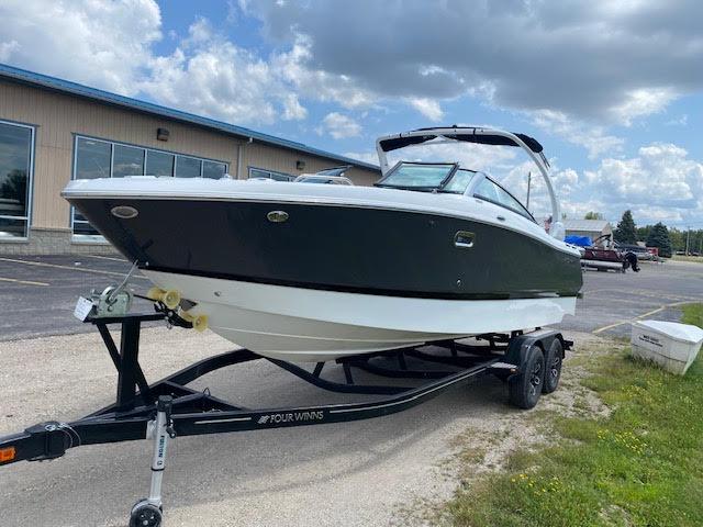 Slide: The Image of 2023 Four Winns H260 boat on a trailer, parked outdoors. - 0