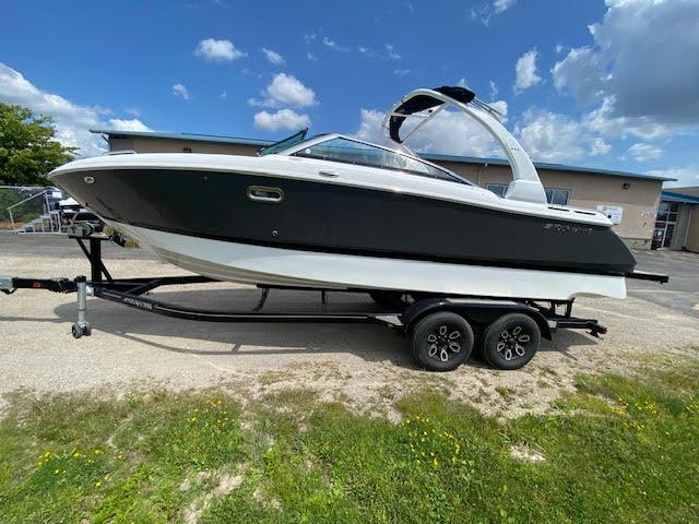Slide: The Image of 2023 Four Winns H260 boat on a trailer under a blue sky. - 1