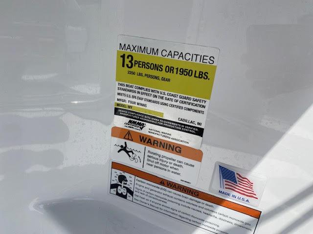 Slide: The Image of 2023 Four Winns H260 boat capacity label: 13 persons or 1950 lbs, made in USA. - 16