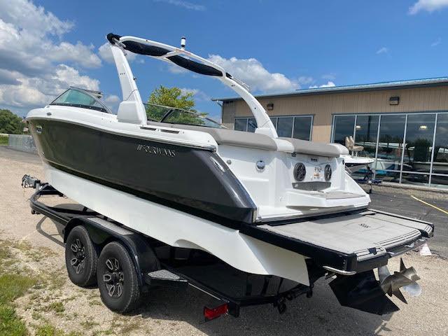 Slide: The Image of 2023 Four Winns H260 boat on a trailer outside a building. - 2
