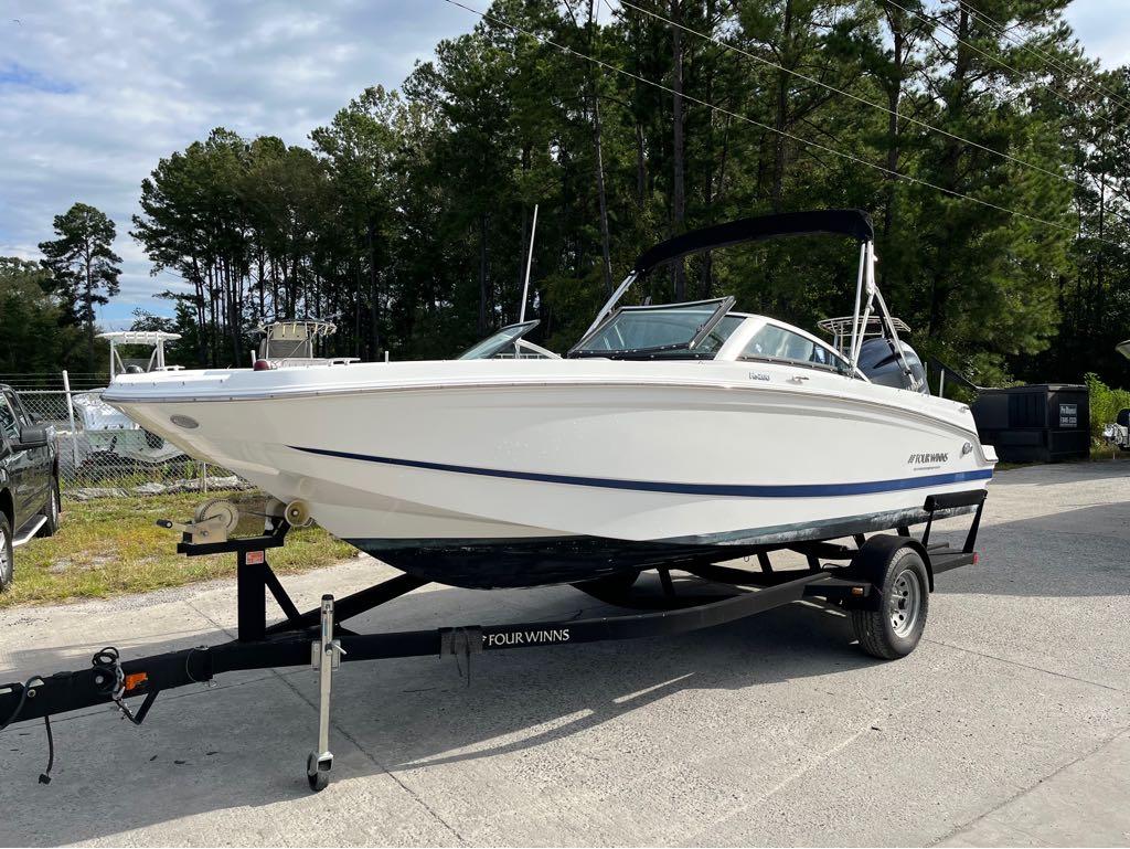 Slide: The Image of 2020 Four Winns HD 200 OB boat on a trailer in a parking lot. - 1