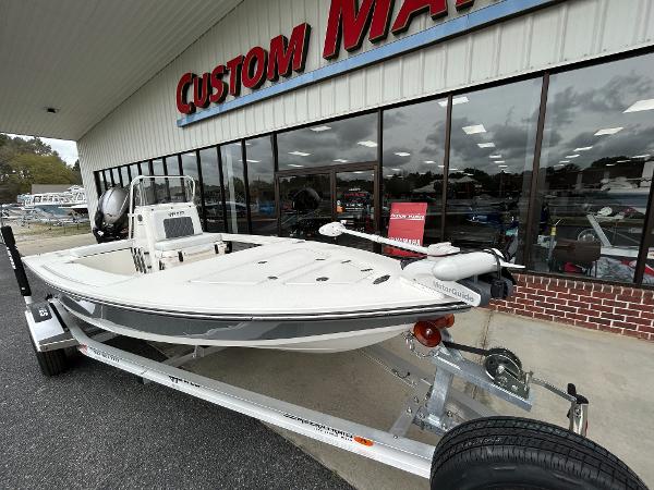 Slide: The Image of 2024 Hewes Redfisher 18 boat on a trailer outside Custom Marine dealership. - 3