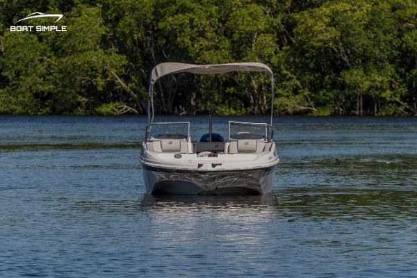 Slide: The Image of 2022 Hurricane 217 SD boat on calm water with lush green background. - 2
