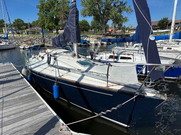 Slide: The Image of 1986 J Boats J30 sailboat docked at marina with blue hull and white deck. - 0