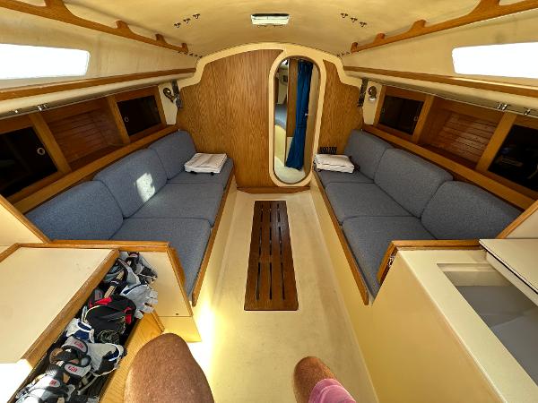 Slide: The Image of Interior of 1986 J Boats J30 sailboat with blue cushions and wooden accents. - 10
