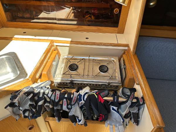Slide: The Image of 1986 J Boats J30 interior galley with stove and gloves. - 12