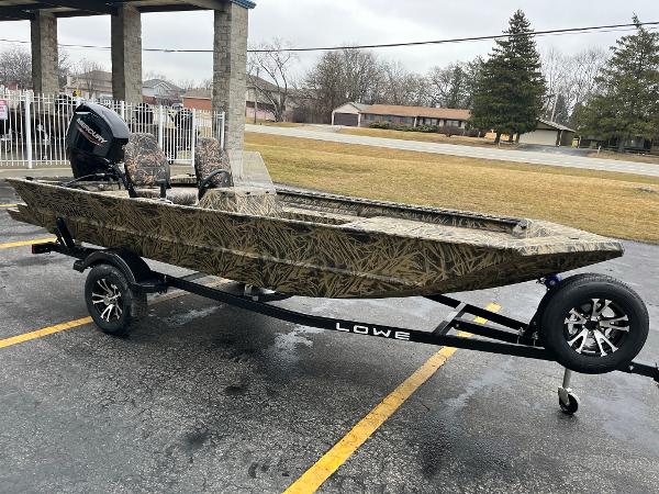 Slide: The Image of 2024 Lowe Roughneck RX1660 SC camo boat on trailer in parking lot. - 4