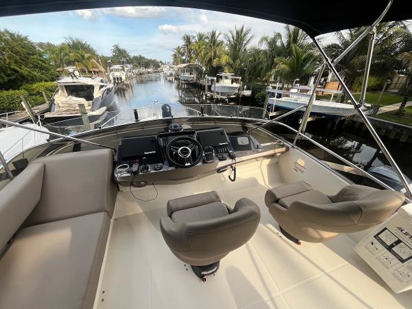Slide: The Image of 2017 Marquis 500 Sport Yacht helm station with waterfront view. - 16