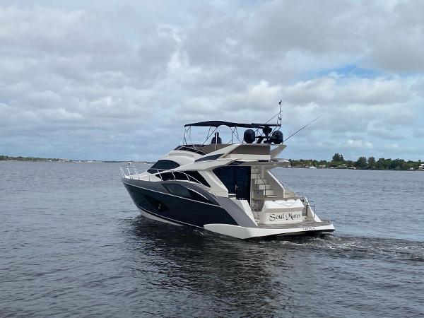 Slide: The Image of 2017 Marquis 500 Sport Yacht cruising on a calm lake under a cloudy sky. - 4