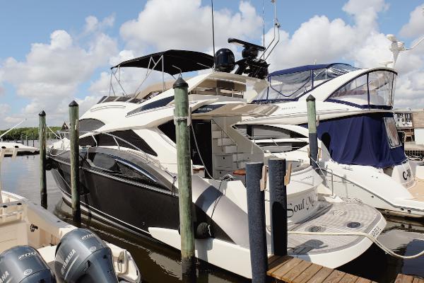 Slide: The Image of 2017 Marquis 500 Sport Yacht docked at marina with other boats. - 7