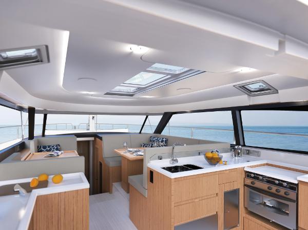 Slide: The Image of 2024 Moody 48 Deck Saloon interior with modern kitchen and ocean view. - 7