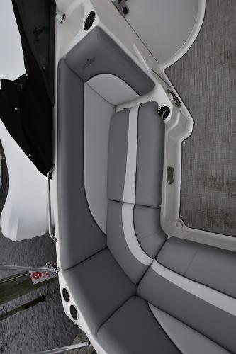 Slide: The Image of 2021 NauticStar 223 DC boat with gray and white cushioned seating. - 8
