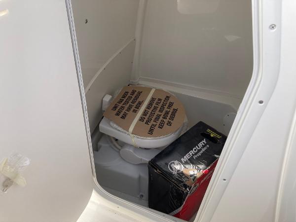 Slide: The Image of 2023 NauticStar 24 Legacy boat interior with toilet and storage. - 13