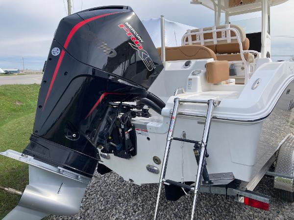 Slide: The Image of 2023 NauticStar 24 Legacy boat with powerful outboard motor and swim ladder. - 2