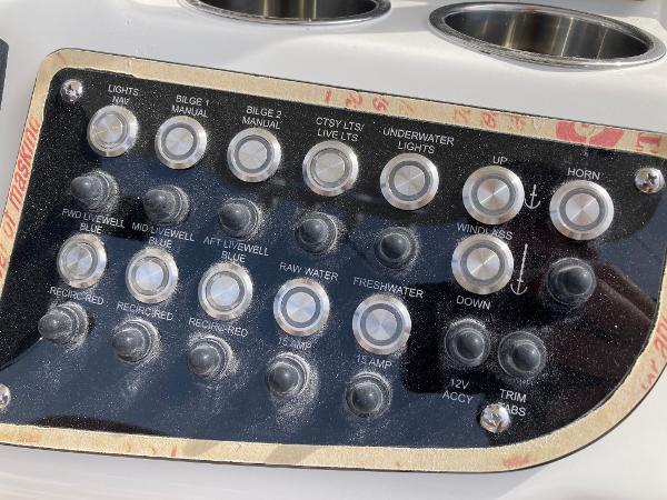 Slide: The Image of Control panel of a 2023 NauticStar 24 Legacy boat with various switches and buttons. - 7