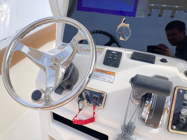 Slide: The Image of 2023 NauticStar 24 Legacy boat helm with steering wheel and controls. - 8