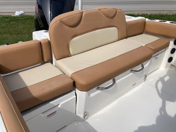 Slide: The Image of 2023 NauticStar 24 Legacy boat with tan and cream cushioned seating. - 9